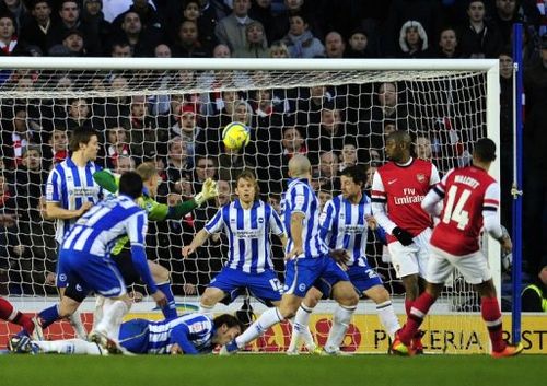 Arsenal's Theo Walcott (R) scores their third goal during their 3-2 win over Brighton & Hove Albion on January 26, 2013