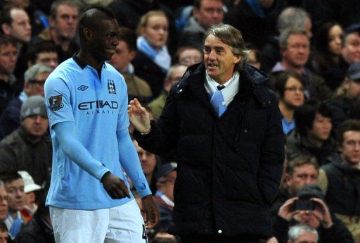 Mario Balotelli (L) shares a joke with Roberto Mancini when coming on as a substitute on January 5, 2013