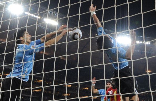 Uruguay&#039;s striker Luis Suarez (L) stops the ball with the hand leading to a red card and a penalty for Ghana during the extra-time of 2010 World Cup quarter-final match Uruguay vs. Ghana on July 2, 2010 at AFP Soccer City stadium in Soweto, suburban Johannesburg.