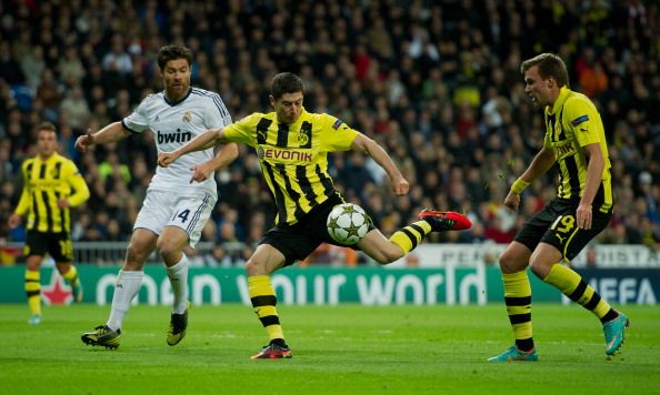 Robert Lewandowski (C) of Borussia Dortmund fires on goal in between Xabi Alonso (L) of Real Madrid and his teammate Kevin Grosskreutz during the UEFA Champions League group D match between Real Madrid and Borussia Dortmund at Estadio Santiago Bernabeu on November 6, 2012 in Madrid, Spain.