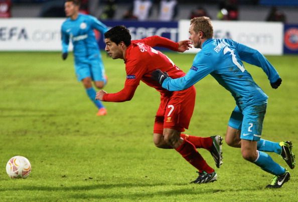 RUSSIA, ST. PETERSBURG - FEBRUARY 14: Alexander Anyukov of FC Zenit St Petersburg battles for the ball with Luis Suarez of Liverpool FC during the UEFA Europa League Round of 32 first leg between FC Zenit St Petersburg and Liverpool FC at the Petrovski stadium on February 14, 2013 in St. Petersburg, Russia. 