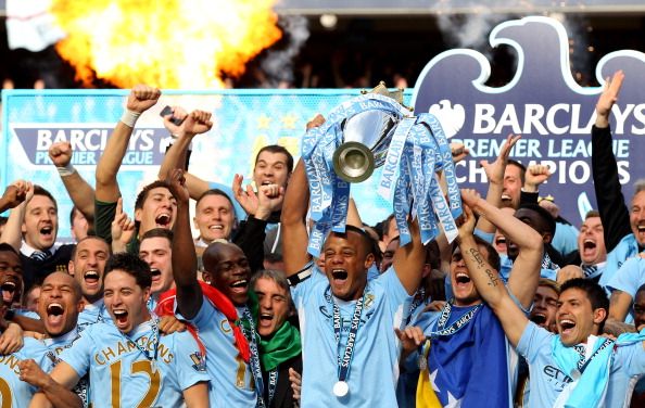 MANCHESTER, ENGLAND - MAY 13:  Vincent Kompany the captain of Manchester City lifts the trophy following the Barclays Premier League match between Manchester City and Queens Park Rangers at the Etihad Stadium