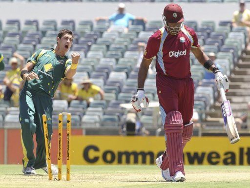 Mitchell Starc (L) celebrates taking the wicket of Kieron Pollard during the one-day international on February 1, 2013