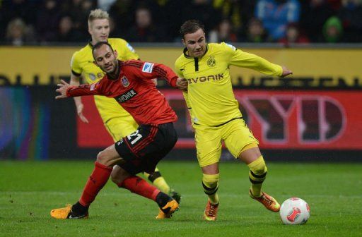 Dortmund&#039;s midfielder Mario Goetze and Leverkusen&#039;s Turkish defender Oemer Toprak vie for the ball on February 3, 2013