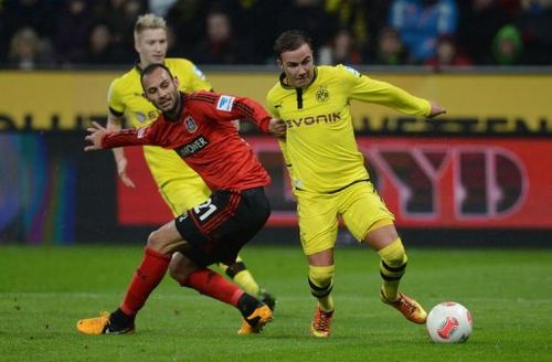 Dortmund's midfielder Mario Goetze and Leverkusen's Turkish defender Oemer Toprak vie for the ball on February 3, 2013