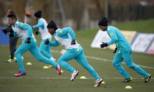Brazil&#039;s Ronaldinho (R) warms up with teammates during a training session in Edgware, London, on February 5, 2013