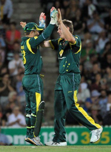 Matthew Wade (left) and James Faulkner celebrate a wicket against West Indies in Canberra on February 6, 2013