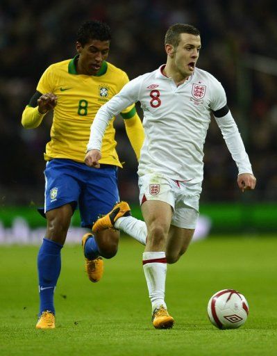 England&#039;s Jack Wilshere tries to shake off Brazil midfielder Paulinho during the friendly at Wembley on February 6, 2013