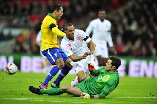 Brazil goalkeeper Julio Cesar (R) denies England&#039;s Theo Walcott during the friendly at Wembley on February 6, 2013