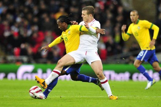 England&#039;s Jack Wilshere (R) challenges Brazil&#039;s Arouca during the friendly at Wembley Stadium on February 6, 2013