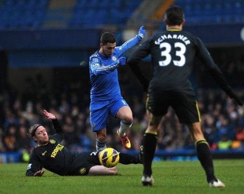 Chelsea's Eden Hazard (C) jumps a slide tackle from Wigan Athletic's Ronnie Stam in London on February 9, 2013