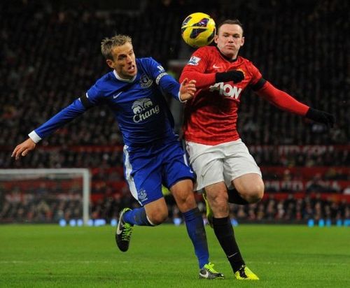 Everton's Phil Neville (L) tangles with Manchester United's Wayne Rooney at Old Trafford on February 10, 2013