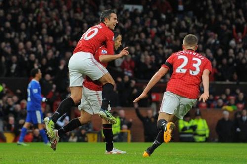 Manchester United's Robin van Persie (L) climbs on the back of Ryan Giggs (C) at Old Trafford on February 10, 2013