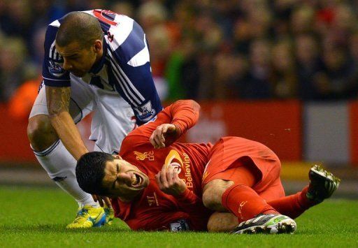 West Brom defender Steven Reid (L) fouls Luis Suarez as the visitors stunned Liverpool 2-0, on February 11, 2013