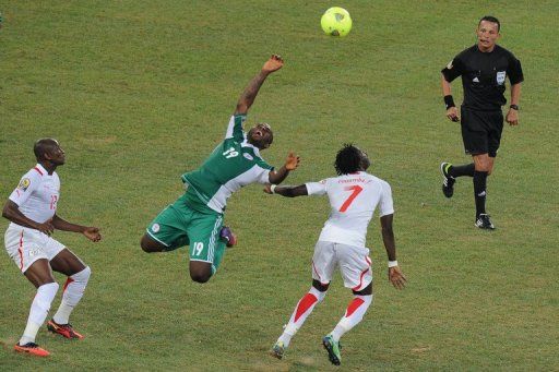 Nigerian forward Sunday Mba (centre) fights for the ball with Burkina Faso&#039;s midfielder Florent Rouamba (second right)