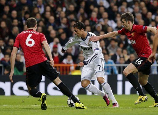 Real Madrid&#039;s Cristiano Ronaldo (C) vies with Manchester United&#039;s Michael Carrick (R) in Madrid on February 13, 2013