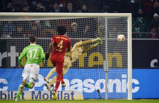 Bayern Munich&#039;s goalkeeper Manuel Neuer (R) saves a free kick in Wolfsburg, northern Germany, on February 15, 2013