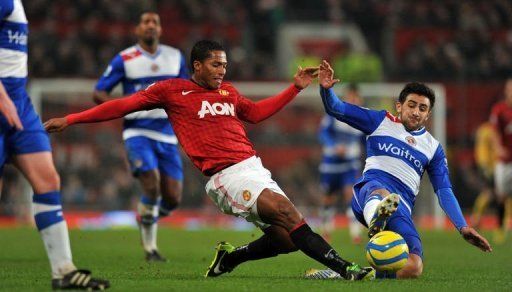 Manchester United&#039;s Antonio Valencia (L) goes for a 50-50 ball with Reading midfielder Jem Karacan, on February 18, 2013