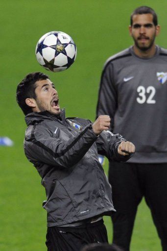 Malaga&#039;s Isco (L) controls a ball in front of teammate Pol Freixanet in Porto, on February 18, 2013