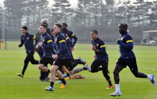 Arsenal&#039;s Aaron Ramsey (C) warms up with teammates at Arsenal&#039;s training ground on February 18, 2013