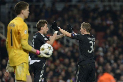 Bayern&#039;s Bastian Schweinsteiger (R) congratulates Mario Mandzukic (C) after he scored in London on February 19, 2013