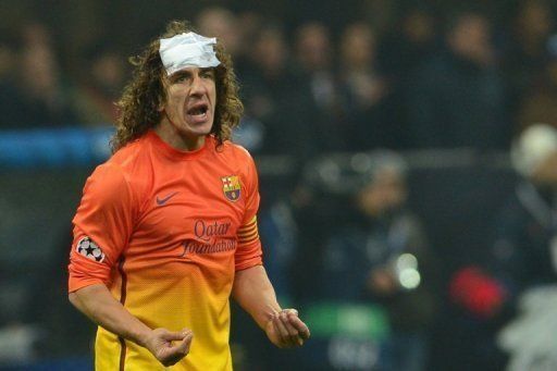 Carles Puyol reacts after being injured during the Champions League match against AC Milan on February 20, 2013