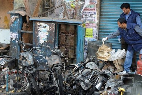 Investigators inspect one of the blast sites at Dilsukh Nagar district in Hyderabad on February 22, 2013.