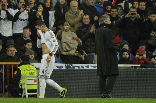 Real Madrid defender Sergio Ramos (L) walks past Real coach Jose Mourinho after being sent off on February 17, 2013