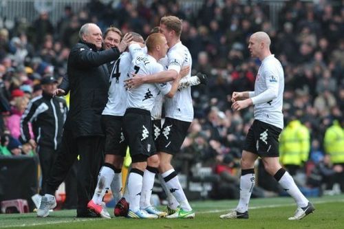 Fulham boss Martin Jol (L) celebrates with his players after Dimitar Berbatov's goal against Stoke on February 23, 2013