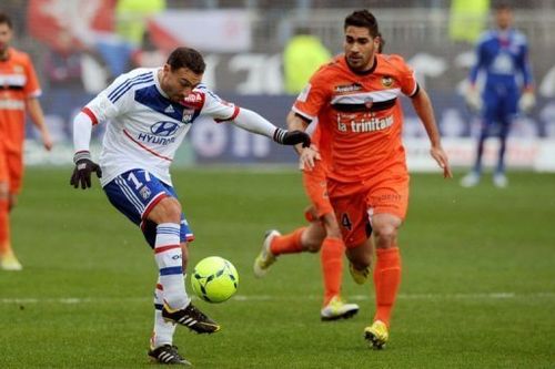 Lyon's Steed Malbranque (L) keeps the ball away from Lorient's Arnaud Le Lan on February 24, 2013