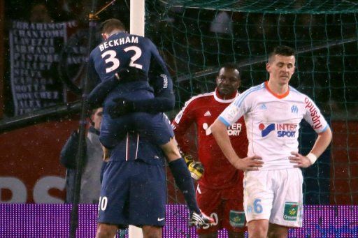 PSG&#039;s David Beckham jumps on teammate Zlatan Ibrahimovic on February 24, 2013 in Paris