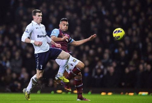 Tottenham winger Gareth Bale (L) challenges West Ham's Winston Reid on February 25, 2013