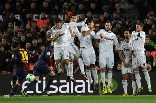 Barcelona's Lionel Messi (L) takes a free-kick at the Camp Nou stadium in Barcelona on February 26, 2013