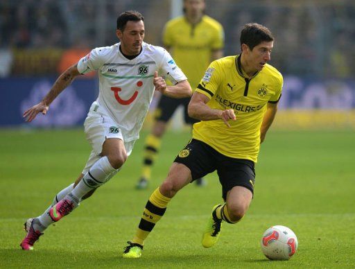 Hanover&#039;s Sergio Pinto (L) and Dortmund&#039;s Robert Lewandowski fight for the ball in Dortmund on March 2, 2013