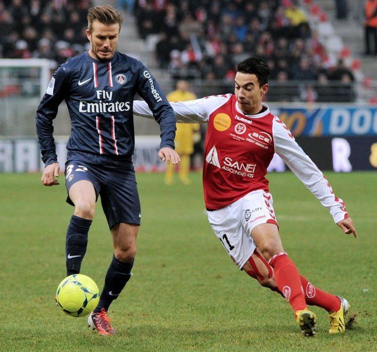 Paris Saint-Germain&#039;s David Beckham (L) clashes with Reims&#039; Diego Rigonato on March 2, 2013 in Reims