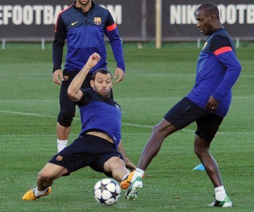 Barcelona midfielder Javier Mascherano (L) and defender Eric Abidal take part in a training session  on March 11, 2013