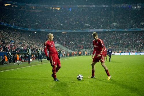 Bayern's Arjen Robben (L) and Thomas Mueller (R) play at the Allianz arena in Munich on March 13, 2013