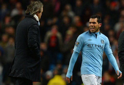 Manchester City&#039;s Carlos Tevez speaks to manager Roberto Mancini during the match against Barnsley March 9, 2013