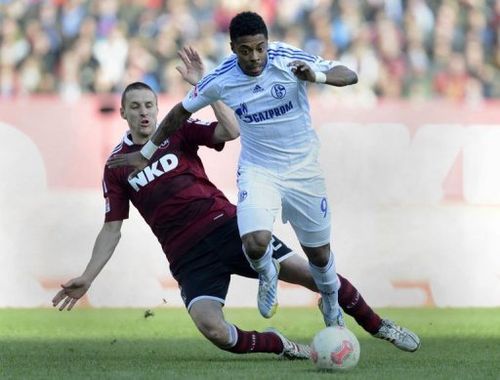 Schalke's Michel Bastos (R) and Nuremberg's Timmy Simons fight for the ball, March 16, 2013 in Nuremberg