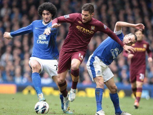 Marouane Fellaini (L) and Leon Osman tackle Javier Garcia (C) in Liverpool on March 16, 2013