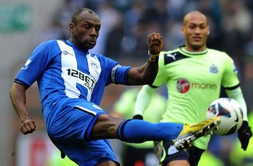 Wigan's Emmerson Boyce (L) clears the ball away from Newcastle's Yoan Gouffran in Wigan on March 17, 2013