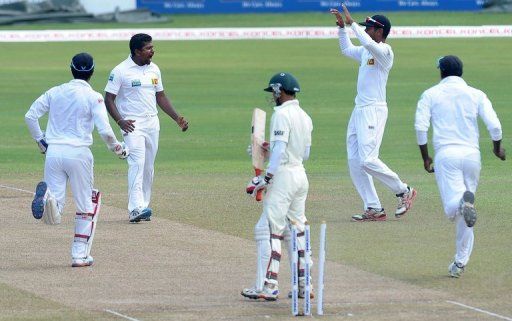 Rangana Herath (2nd left) celebrates with teammates after dismissing Nasir Hossain (centre) in Colombo on March 19, 2013