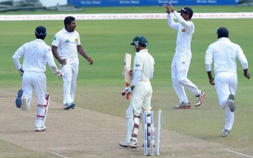 Rangana Herath (2nd left) celebrates with teammates after dismissing Nasir Hossain (centre) in Colombo on March 19, 2013