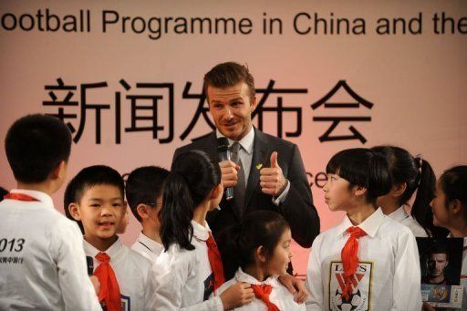 David Beckham (C) answers questions from a group of pupils at a primary school in Beijing on March 20