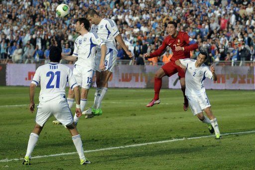 Portuguese forward Cristiano Ronaldo (R) fights for the ball against Israel on March 22, 2013