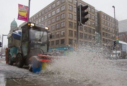 A road sweeper tries to clear snow from the pavements in Belfast City centre in Northern Ireland, on March 22, 2013