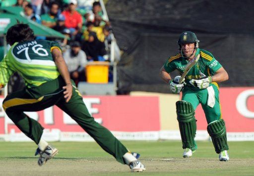 AB de Villiers (R) looks on as Mohammad Irfan (L) tries to catch him out in Benoni on March 24, 2013