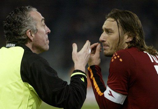 Francesco Totti (R) argues with the side referee during a Serie A match against Inter Milan on March 7, 2004