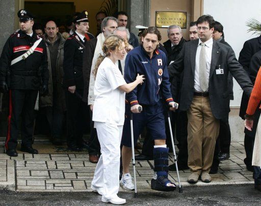 Francesco Totti (C) leaves the Villa Stuart hospital in Rome on February 22, 2006