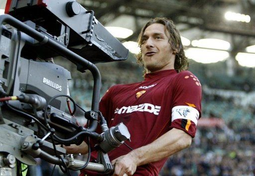 Francesco Totti celebrates with a TV camera after scoring at Rome&#039;s Olympic stadium on April 21, 2004
